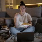 woman-eating-fast-food-while-watching-movie